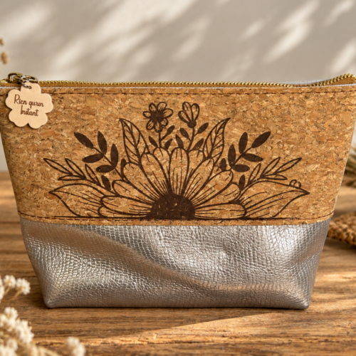 Trousse artisanale en cuir argenté et liège naturel gravé d’une composition de fleurs et feuillages.
