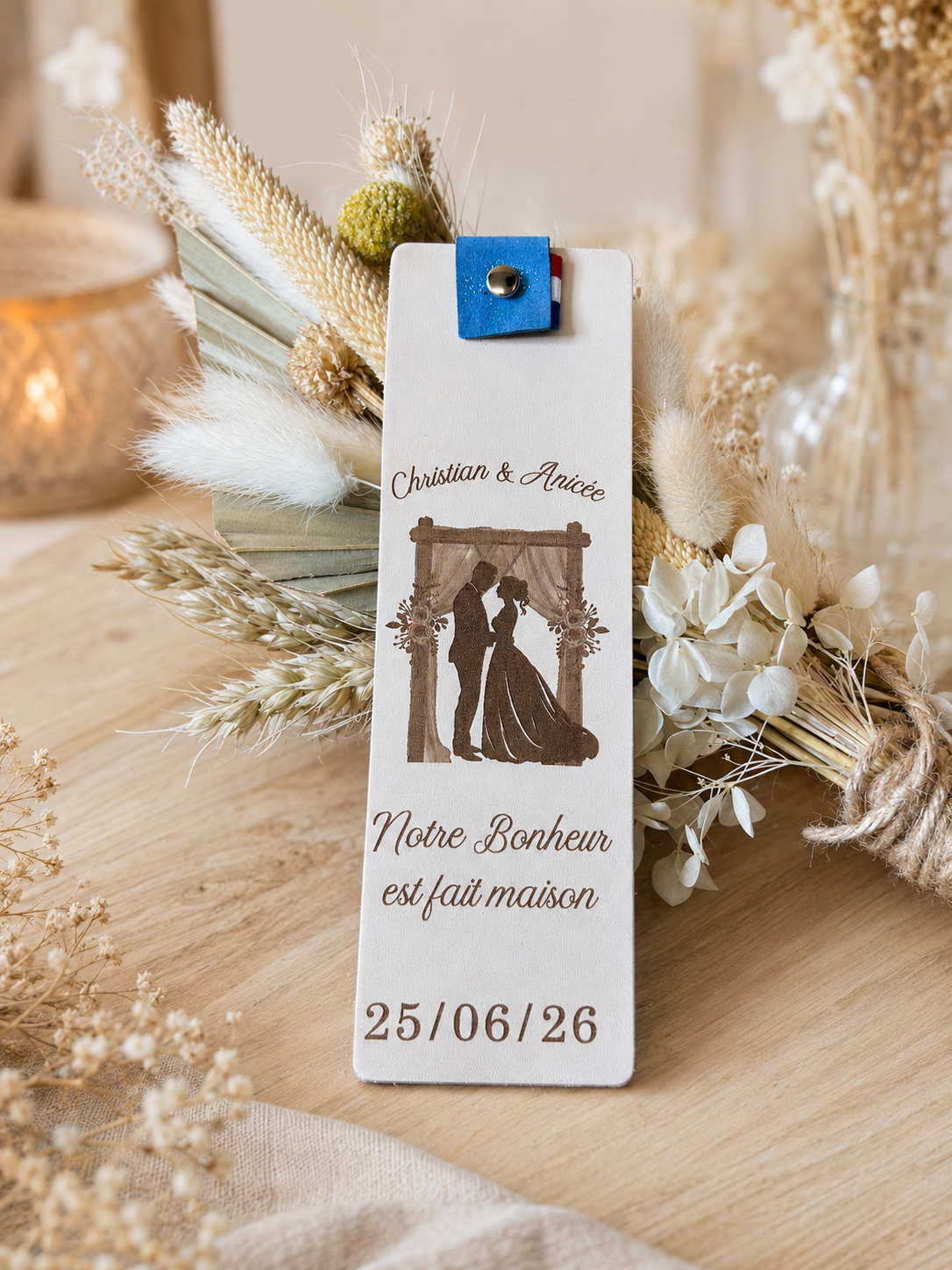 Marque page cadeau invité mariage2 Marque-page personnalisé en cuir tannage végétal posé sur une table de mariage avec décoration florale